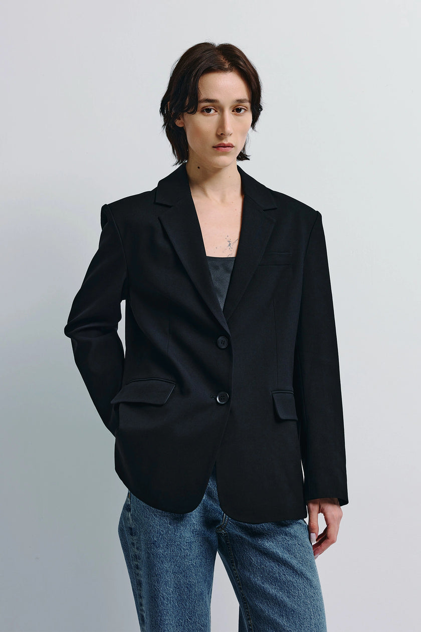Black Walker Oversized Blazer worn by a woman with denim jeans. Two-button front.