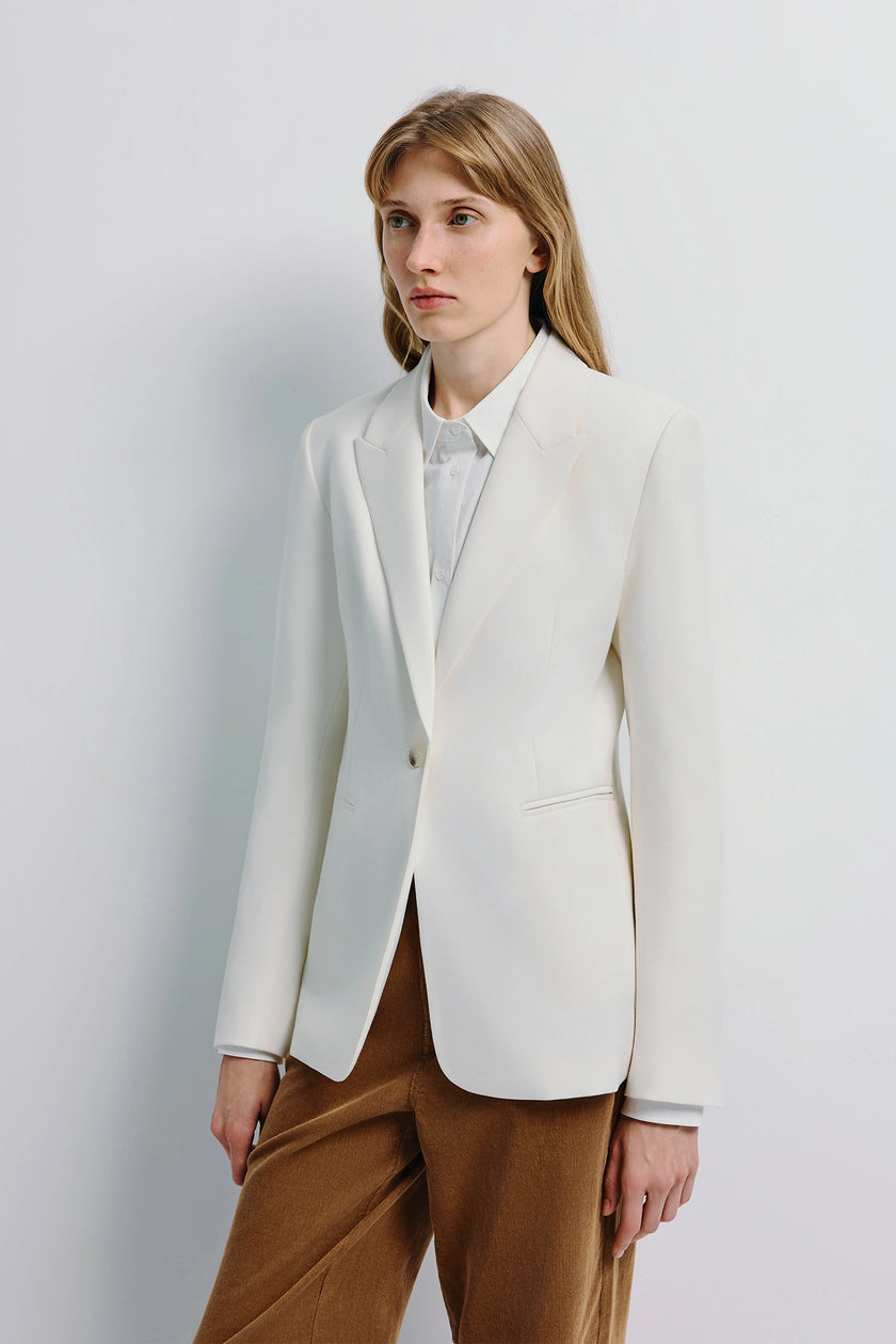 Colette Blazer in white, wool-blend suiting, featuring clean welt pockets, worn with corduroy pants.
