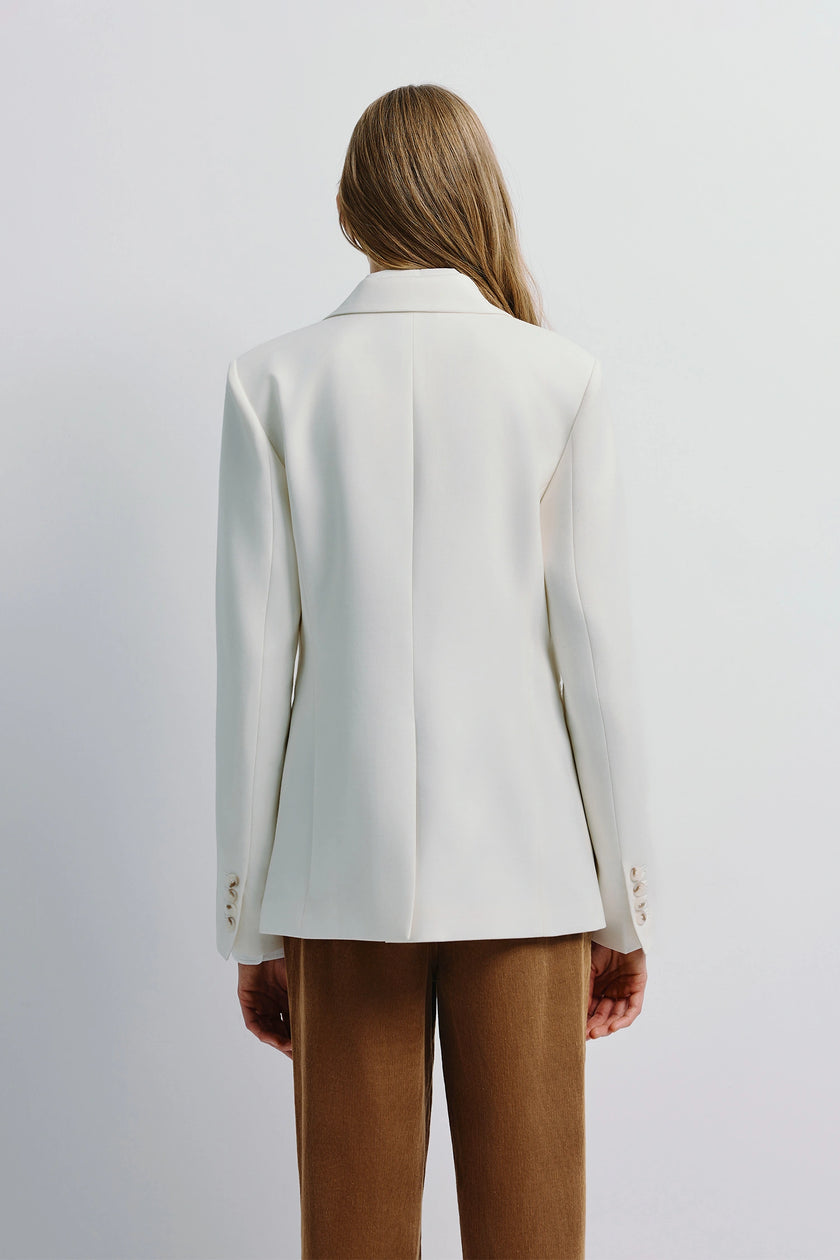 Colette Blazer in white, featuring a tailored fit and single-button design, paired with brown corduroy pants
