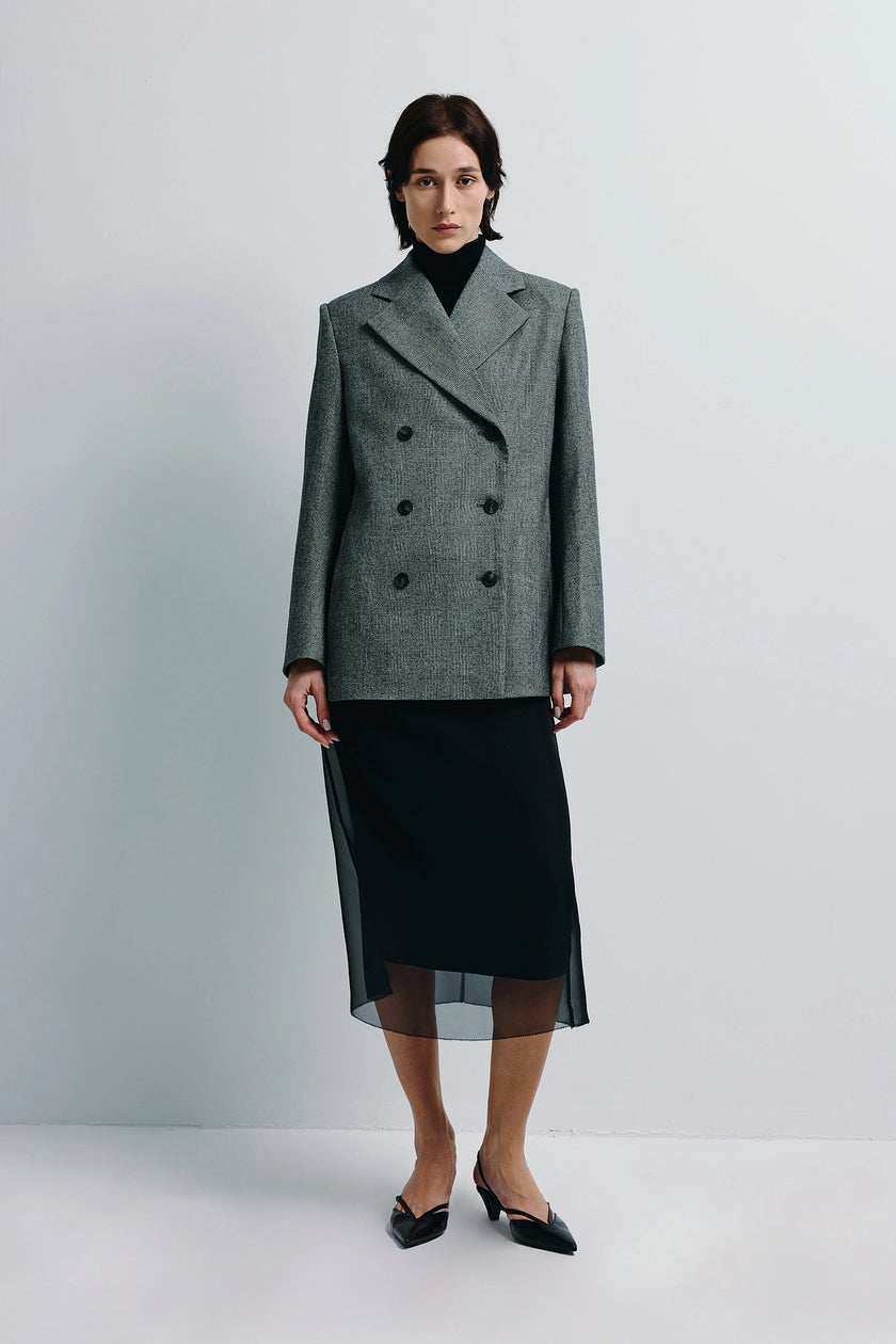 Emery Plaid Blazer in grey wool with strong shoulders, double breasted, paired with black skirt. Modern balance