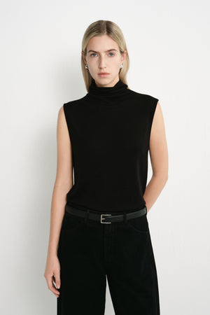 A model wearing a Rue Sophie black sleeveless mock-neck top with extended shoulders and a relaxed straight fit, front view.
