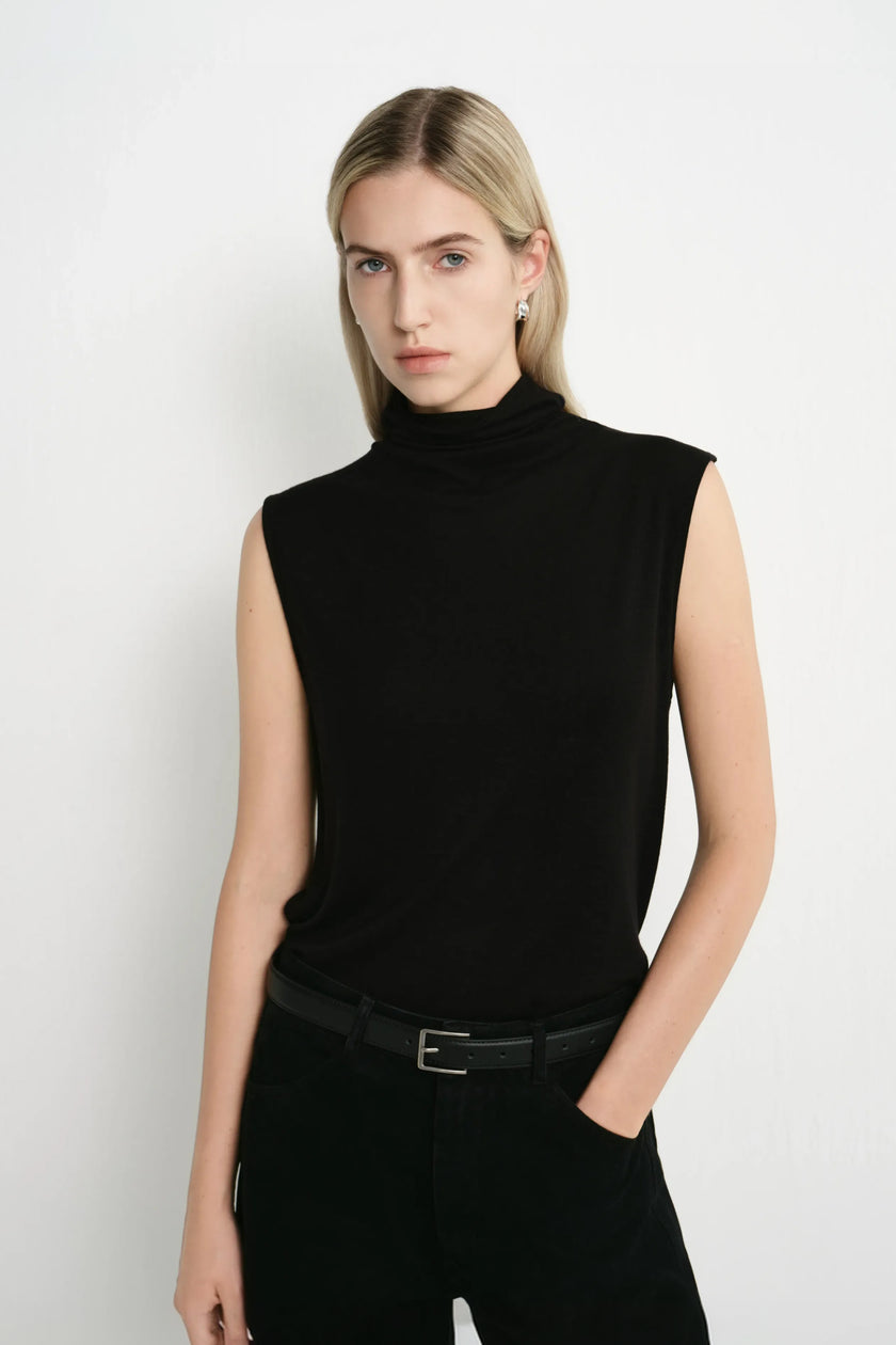 A model wearing a Rue Sophie black sleeveless mock-neck top with a softly draped neckline and relaxed silhouette, three-quarter front view.