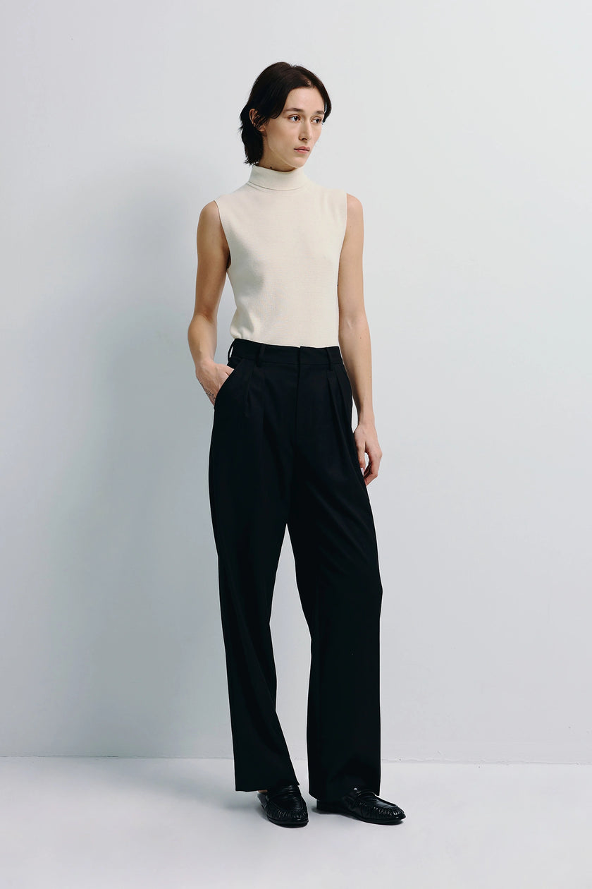 Lilou Sleeveless Turtleneck Top in cream wool knit with black trousers, modern women's fashion