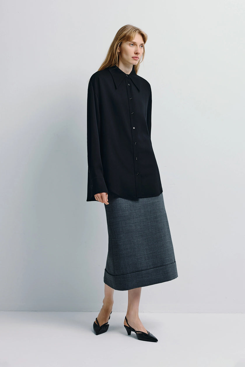 Black Darrion Pointy Collared Shirt, point collar, button front, paired with gray skirt. Sophisticated and minimalist style.