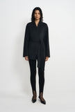 A model facing forward in a heather-grey wool-alpaca-blend short coat tied at the waist, styled with black split-hem leggings and pointed shoes.