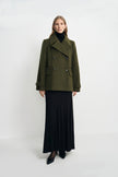 A model wearing a black fluid viscose maxi skirt, pairing an olive double-breasted jacket.