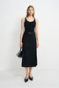 A model wearing a black wool-blend midi skirt with an overlapping front panel, styled with a black tank, narrow belt, pointed shoes and small handbag.