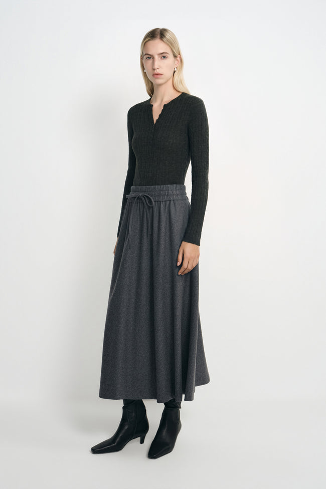 A model wearing the Rue Sophie Elowyn Swing Skirt in Heather Grey, featuring a flowing A-line silhouette and drawstring elastic waist, shown at a three-quarter angle.