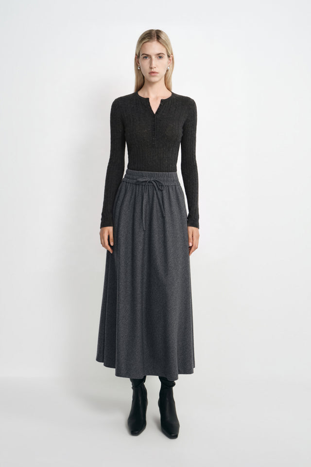 A model wearing the Rue Sophie Elowyn Swing Skirt in Heather Grey, a full-length A-line skirt with a gathered drawstring waist, shown from the front.