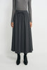A model wearing a dark gray midi skirt with an elastic drawstring waist, paired with a gray long-sleeve top and black ankle boots, against a plain light gray background.