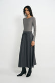 A woman modeling a gray long-sleeve knit top paired with a dark gray high-waisted midi skirt featuring a drawstring waist, styled with black ankle boots against a light gray studio background.