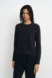 A model wearing a charcoal wool crewneck sweater, facing the camera.