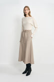 A model wearing an ivory long sleeve top with a wide neckline, pairing a khaki midi skirt with a tie waist.