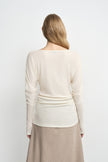 Close-up of an ivory top showing the soft draped fabric across the shoulders and back.