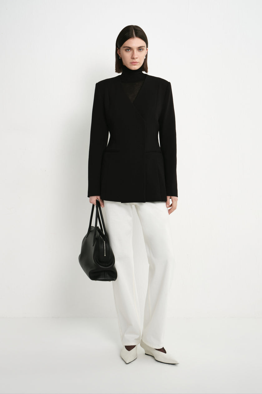 A model wearing the Rue Sophie Marion Side Slit Jacket in black with a collarless V-neckline, structured shoulders, and a fitted tailored shape, full-length front view.
S424JS561_BLACK-2.jpg	A model wearing the Rue Sophie Marion Side Slit Jack