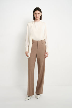 A model wearing Rue Sophie oak high-waisted wide-leg trousers with a clean waistband, belt loops, and full-length tailored legs, front view.