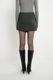 Back view of a model wearing the Rue Sophie Alina Asymmetric Mini Skirt in H. Charcoal, featuring a clean high-waisted silhouette and straight mini hem.