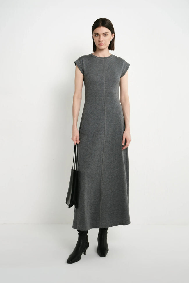 A model wearing the Rue Sophie Avi Out Stitched Dress in heather charcoal with cap sleeves, center-front stitching, and a softly flared maxi silhouette, front view.