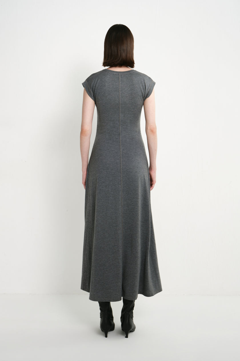Back view of a model wearing the Rue Sophie Avi Out Stitched Dress in heather charcoal, featuring cap sleeves, center-back stitching, and a flowing A-line silhouette.