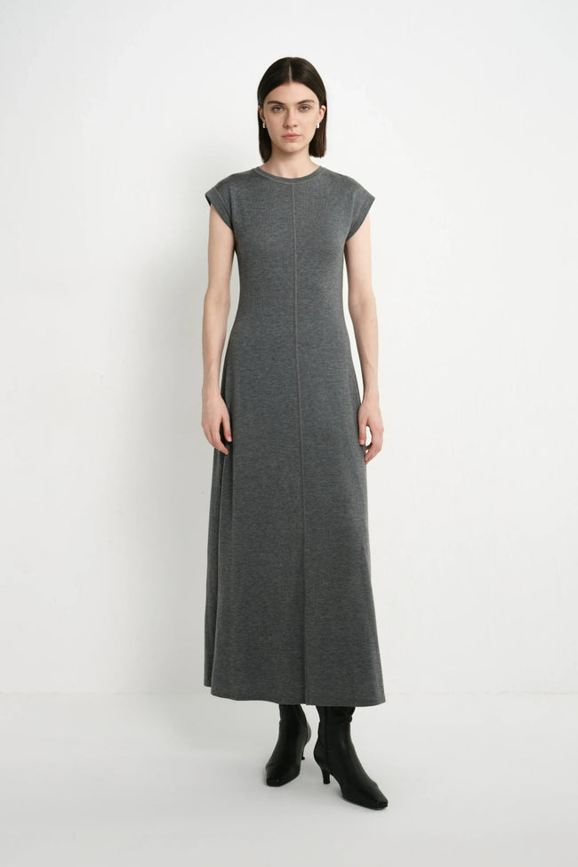 A model wearing the Rue Sophie Avi Out Stitched Dress in heather charcoal, featuring cap sleeves, exposed center-front stitching, and a long A-line silhouette, front view.