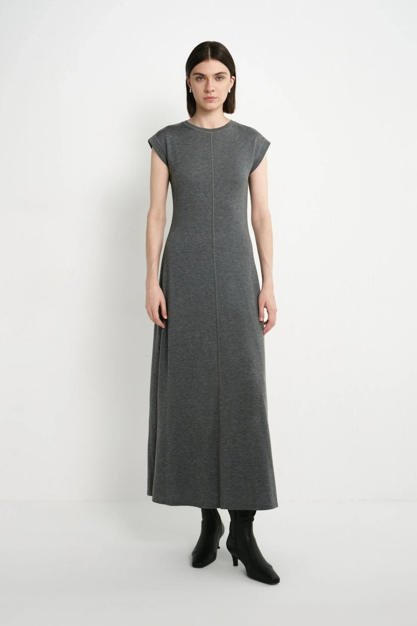 A model wearing the Rue Sophie Avi Out Stitched Dress in heather charcoal, featuring cap sleeves, exposed center-front stitching, and a long A-line silhouette, front view.