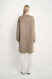 Back view of a model wearing a Rue Sophie oak collarless long coat with dropped shoulders, wide sleeves, and a clean straight silhouette.