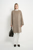 A model wearing a Rue Sophie oak collarless long coat with a clean front closure, oversized patch pockets, and relaxed drop shoulders, front view.