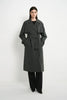A model wearing the Rue Sophie Gavin Trench Coat in H. Charcoal with wide lapels, double-breasted buttons, a belted waist, and a relaxed tailored fit, three-quarter front view.