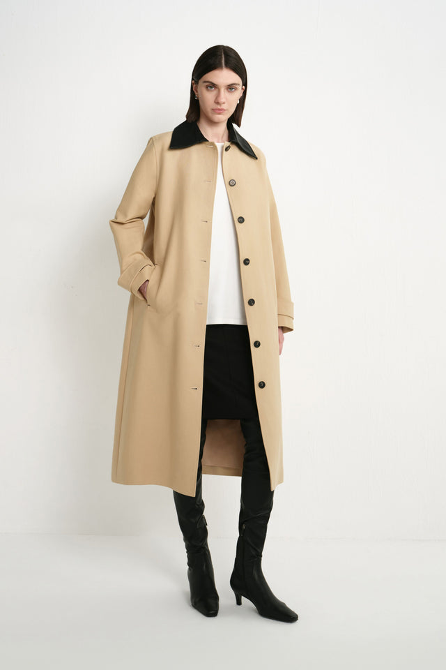 A model wearing the Rue Sophie Vinni Pu Collar Car Coat in khaki, featuring a contrast black pointed collar, button-front closure, side pockets, cuff tabs, and a relaxed long silhouette, front view.