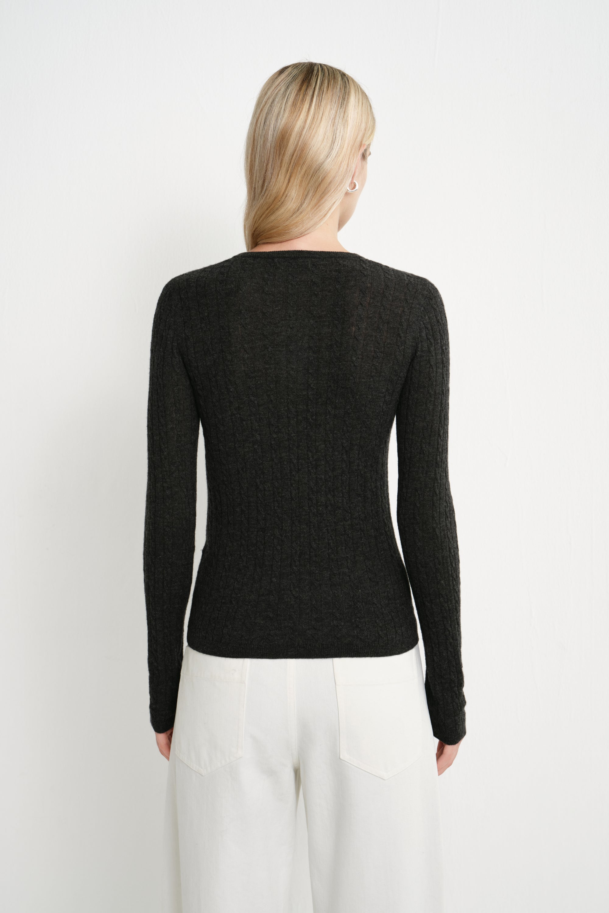 Back view of a model wearing the Rue Sophie Richie Button Up Cable Sweater in heather grey, highlighting the fitted silhouette, long sleeves, and cable-knit texture.