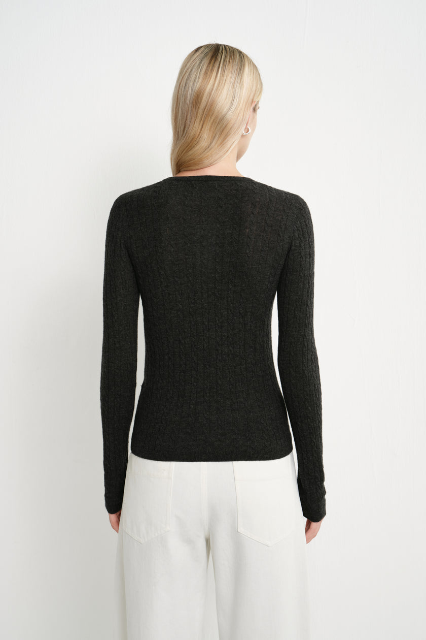 Back view of a model wearing the Rue Sophie Richie Button Up Cable Sweater in heather grey, highlighting the fitted silhouette, long sleeves, and cable-knit texture.