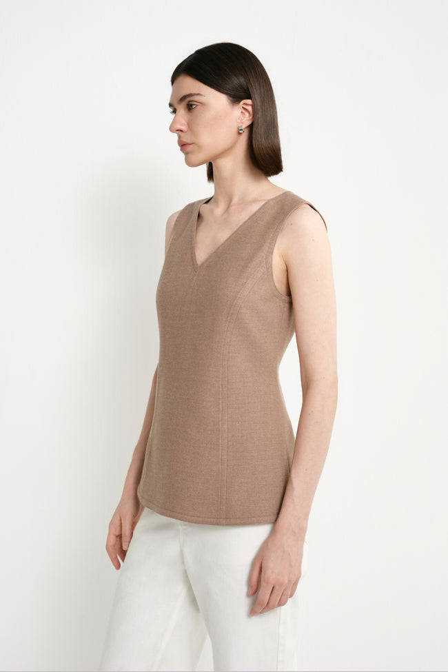 Three-quarter close-up of a model wearing the Rue Sophie Jesi V-Neck Top in Oak, highlighting the V neckline and contoured side seam construction.